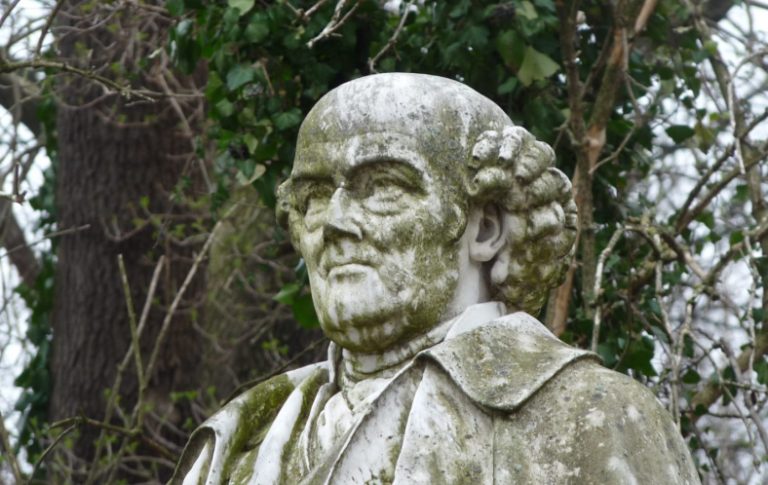 Samuel Hahnemann Porträt einer alten Statue mit moosbedecktem Gesicht und lockigem Haar.